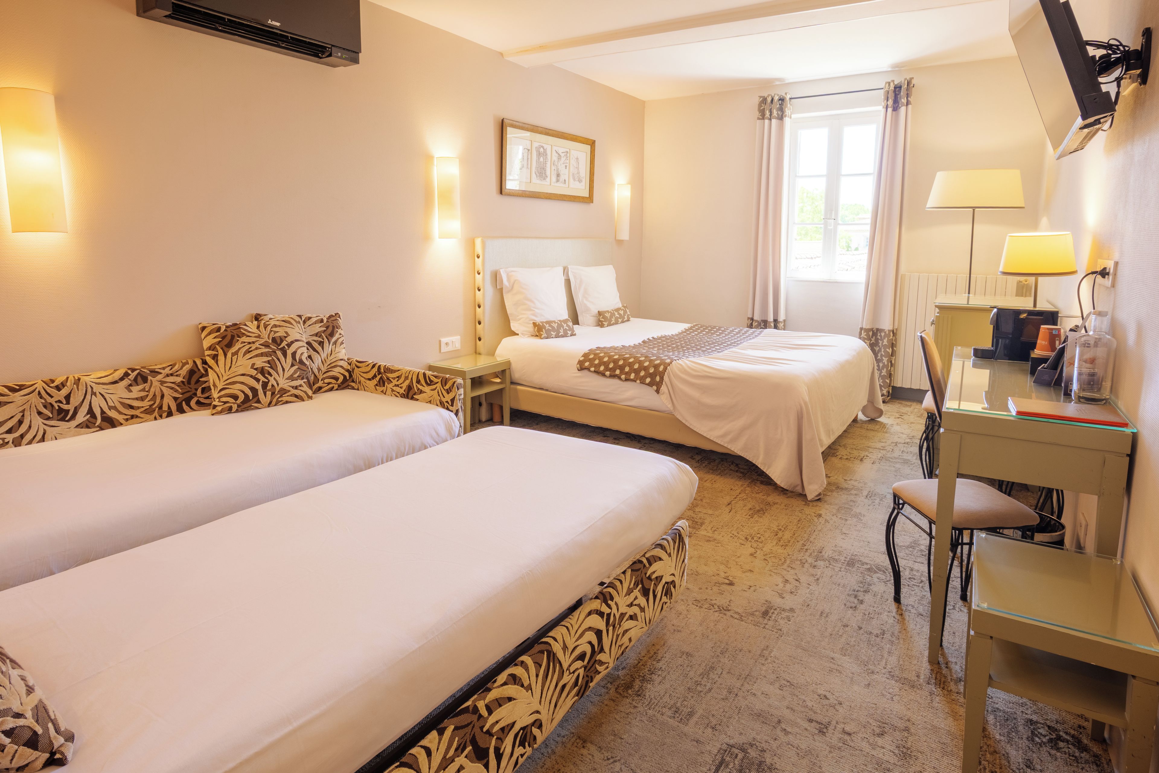 Una habitación de hotel con dos camas, un escritorio y una silla.