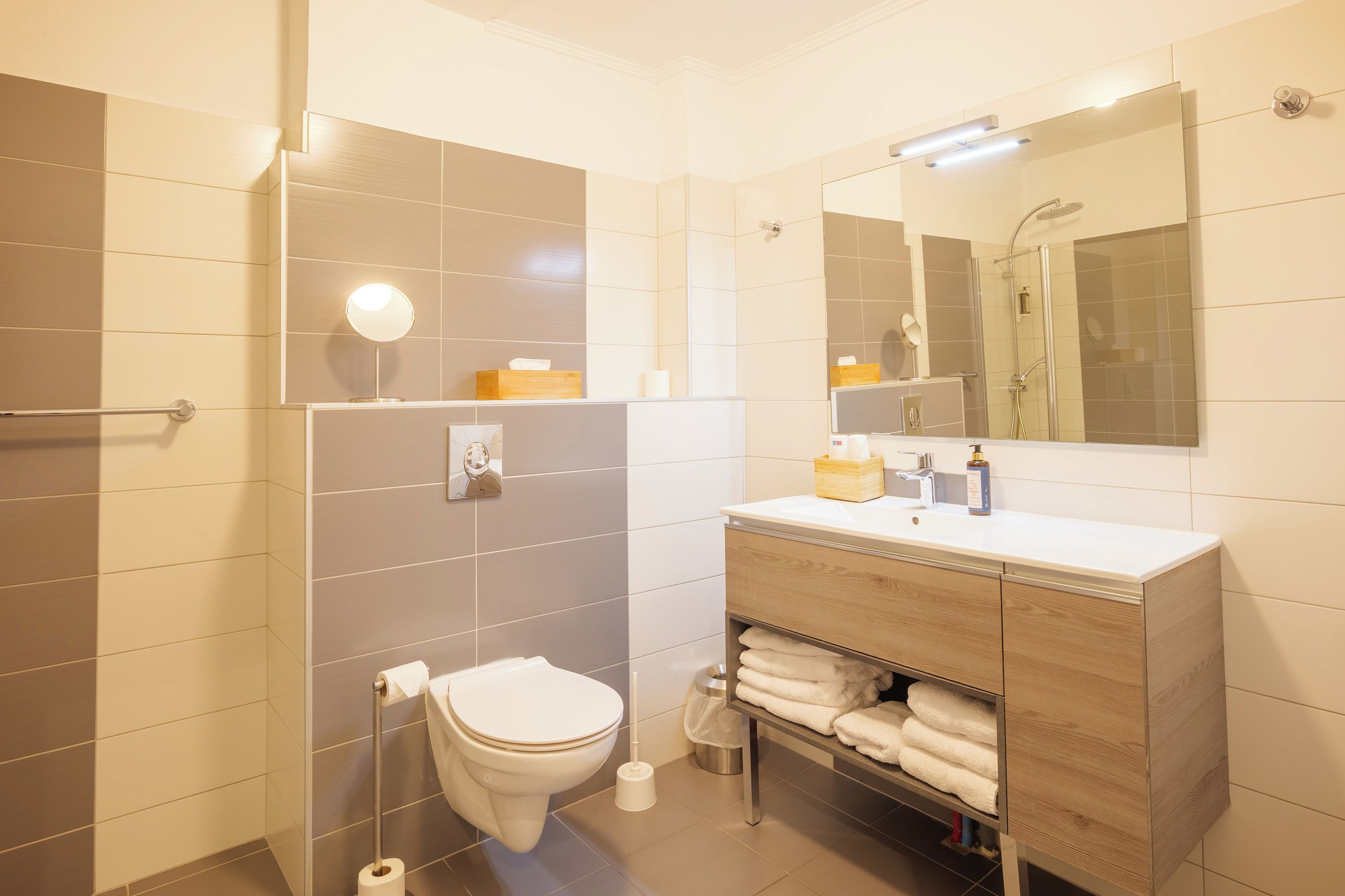 A modern bathroom with a toilet, sink, and shower.