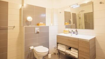 A modern bathroom with a toilet, sink, and shower.