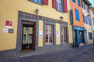 A hotel facade with a sign reading 'HOTEL DU PONT VIEUX' and a 'HOTEL' sign above the entrance.
