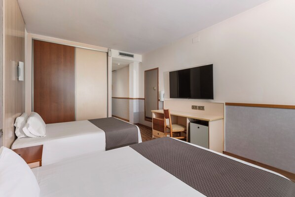 A hotel room with two beds, a desk, a chair, a television, and a wardrobe. - RVHotels Ametlla Mar (L'Ametlla de Mar)