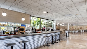 A bar area with a counter, stools, and a view of the outside. - RVHotels Ametlla Mar (L'Ametlla de Mar)
