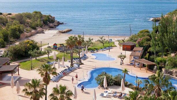 A resort with a swimming pool, lounge chairs, and a beach. - RVHotels Ametlla Mar (L'Ametlla de Mar)