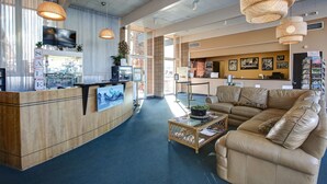 A reception area with a wooden counter, a television, and a large sofa.