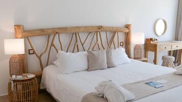 Un letto rifatto con lenzuola bianche, una testata in legno e un comodino con una lampada.