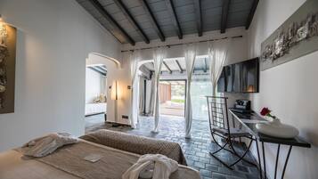 A hotel room with a bed, a desk, a TV, and a view of the outside.