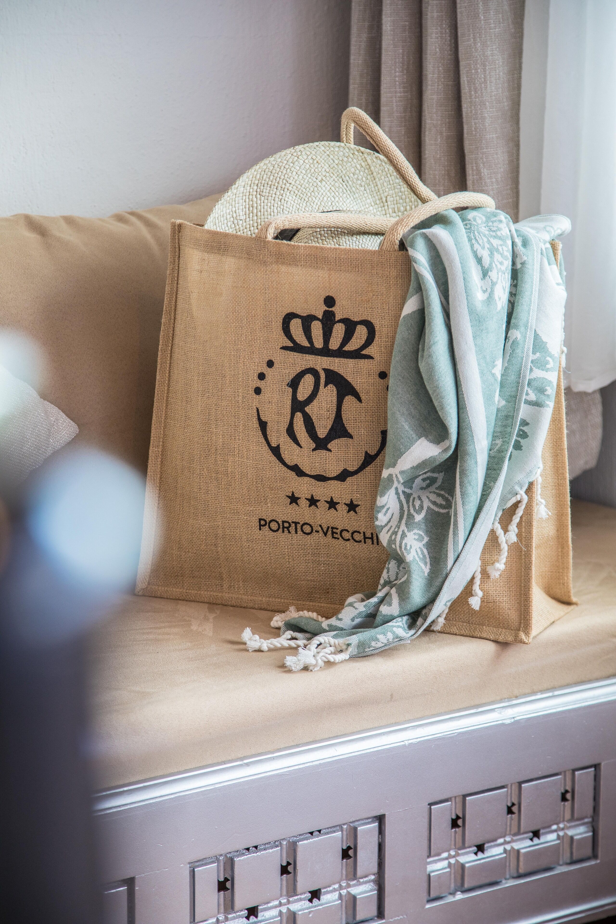 Un sac en papier brun orné d’un logo et d’un texte, posé sur un canapé beige.