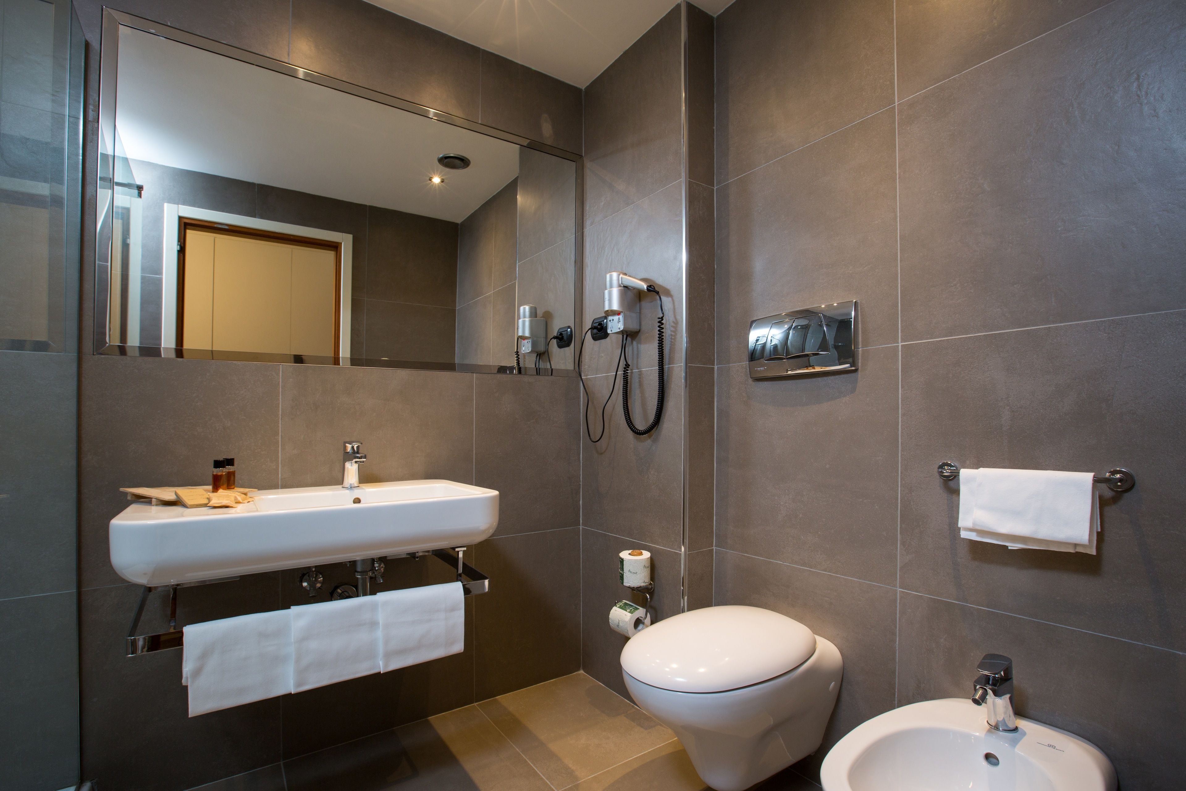 Un baño moderno con lavamanos, inodoro y bidé.