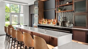 A modern kitchen with a large island, bar stools, and a wine rack. - Delta Hotels by Marriott Midwest City at the Reed Conference Center (Midwest City)