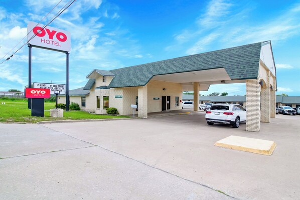 A two-story OYO Hotel with a covered entrance and a parking area.