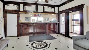 Eine Lobby mit einer Rezeption, einem Deckenventilator, einem gemusterten Boden und einem Sofa.