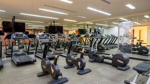 A gym with multiple treadmills, ellipticals, and weight machines.