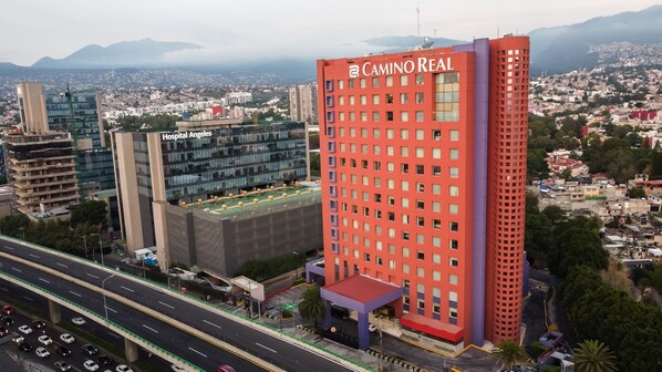 A multi-story hotel with a prominent red facade and the name "Caminorreal" on the top.