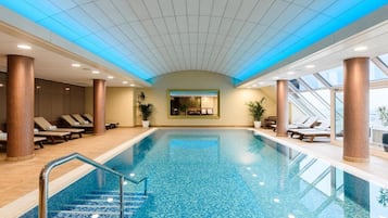 Relax by the pool surrounded by lounge chairs and sun loungers.