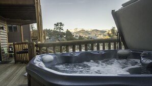 A hot tub on a wooden deck with a view of mountains in the background. - Marys Lake Lodge Mountain Resort and Condos (Estes Park)
