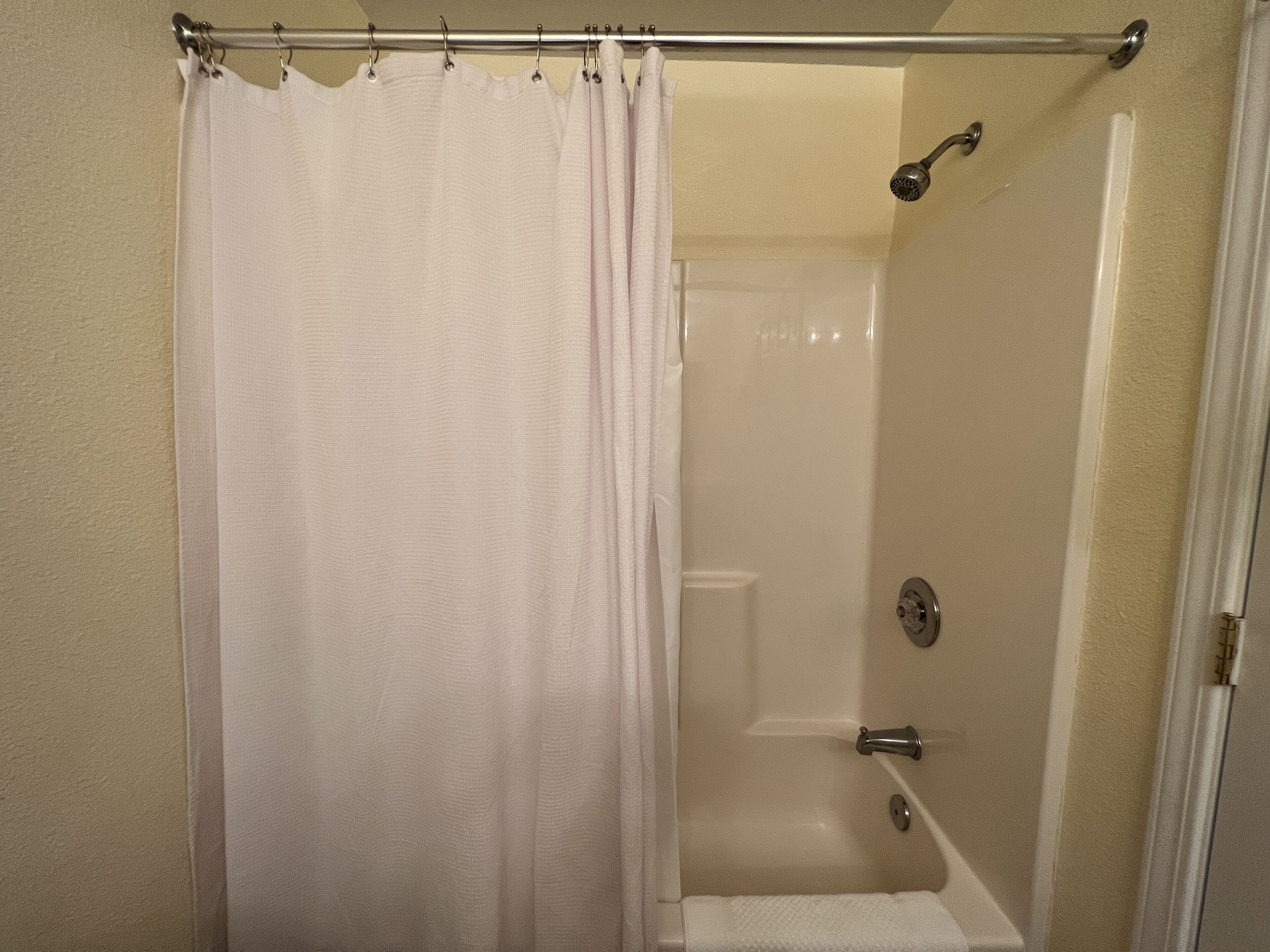Un baño con cortina de ducha, bañera y ducha.