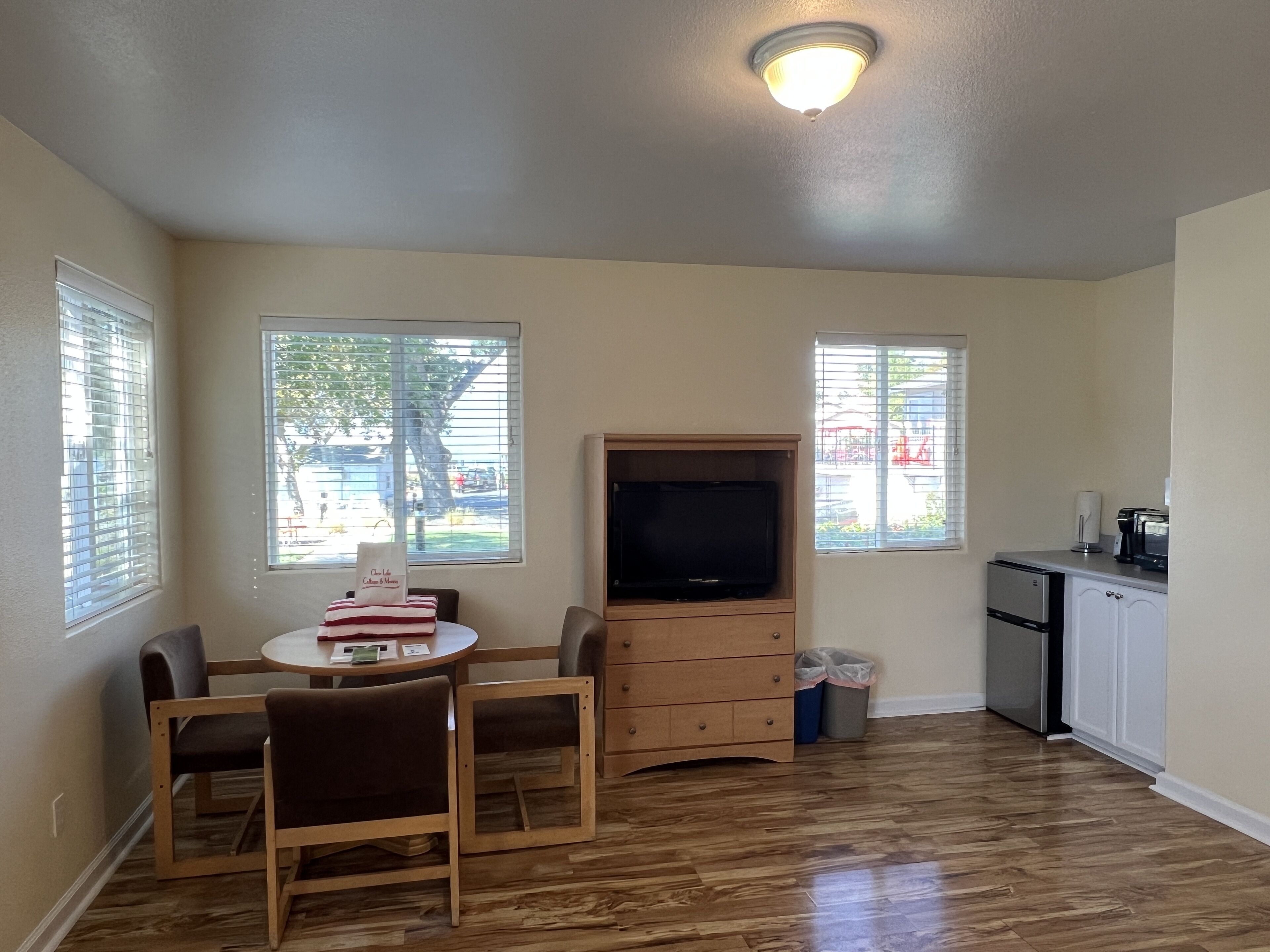 A compact living space with a dining area, a kitchenette, and a TV.