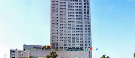 Un grand hôtel moderne, avec une façade en verre et de nombreux étages.