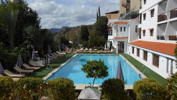 Una piscina al aire libre, tumbonas