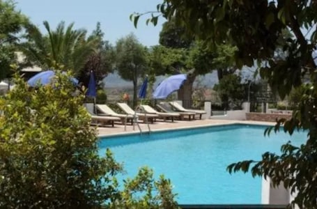 Una piscina al aire libre, sillones reclinables de piscina