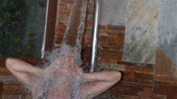Una persona en una bañera con un espejo encima.