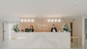 Una recepción con encimera de mármol, dos recepcionistas y un cartel que dice "EL Mirador".
