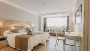 Una habitación de hotel moderna con una cama grande, un escritorio y una zona de estar cómoda.