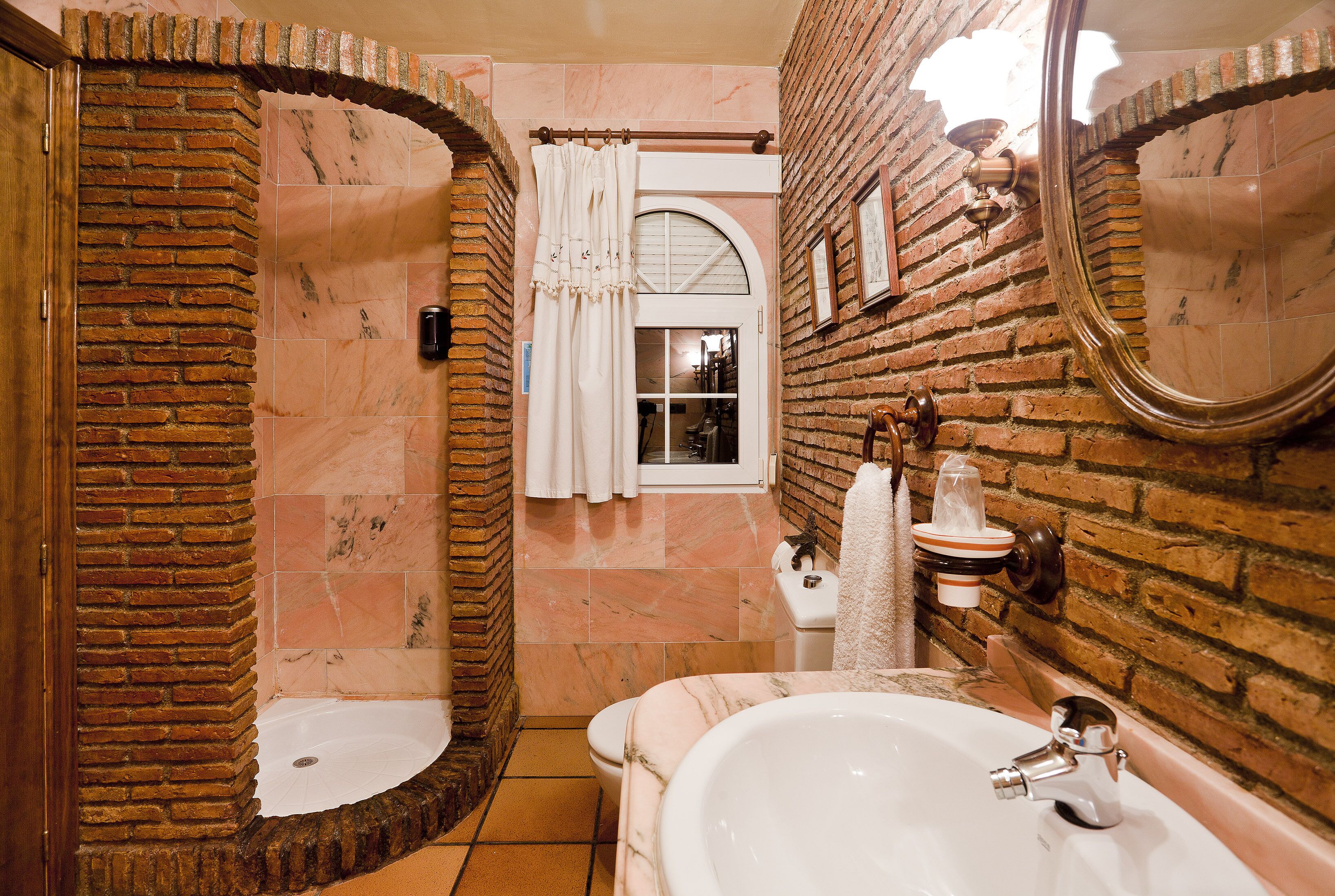Een badkamer met een grote spiegel, een bad en een douchehoek.