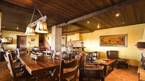 Un comedor rústico con una mesa de madera, sillas y una chimenea de ladrillo.