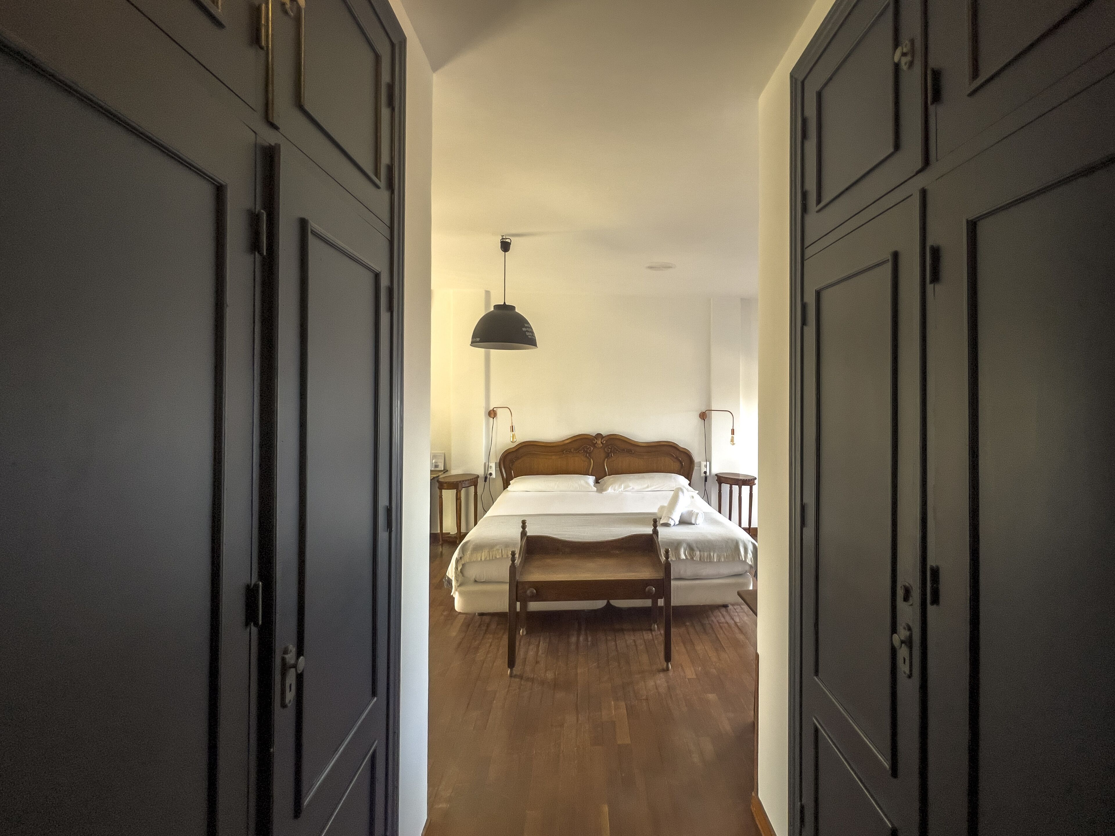 Un dormitorio con una cama de madera, una mesita de noche y una lámpara.