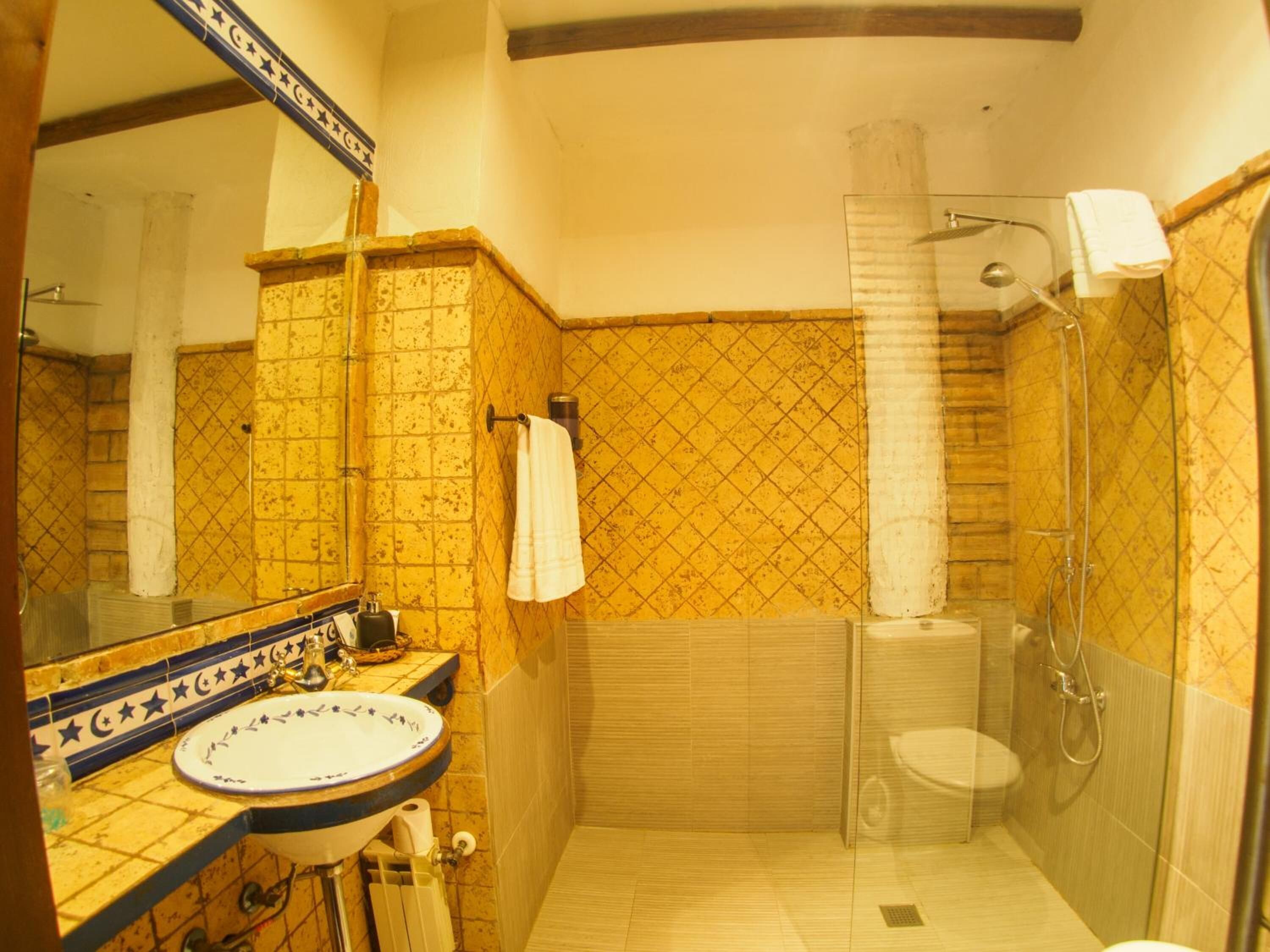 Un bagno con lavandino, specchio e doccia.
