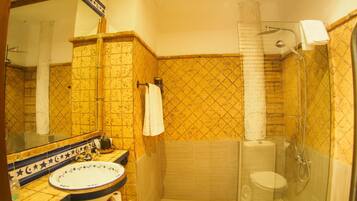 A bathroom with a sink, mirror, and shower.