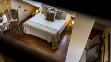 A neatly made bed with pillows and a bedside table with a lamp.
