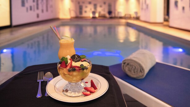 A dessert on a table near a poolside area with a towel and a fork. - Hotel Alejandro I, Affiliated by Meliá (Salta)