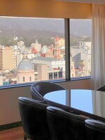 A hotel room with a large window offering a view of a cityscape, including a prominent church with a red dome.