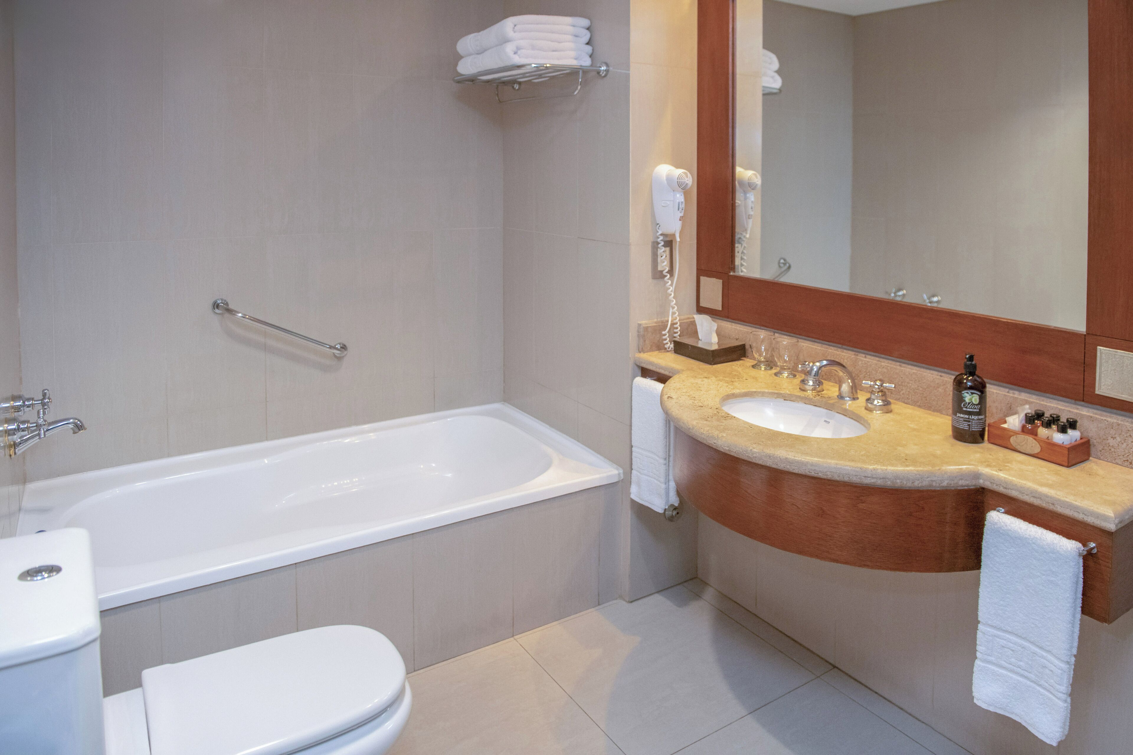 A modern bathroom with a bathtub, toilet, and sink.