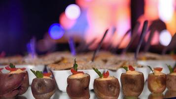 A row of appetizers on a glass tray, with a blurred background featuring bokeh lights.