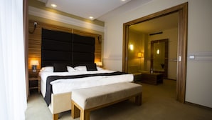 A hotel room with a large bed, a bench, a wooden headboard, and a mirror. - Art Hotel William (Bratislava)