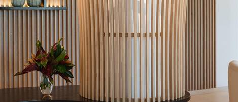 A modern reception desk with vertical wooden slats and a glass top.