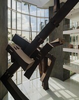 Um interior moderno com uma ampla janela de vidro, uma escultura metálica geométrica e uma varanda espaçosa.