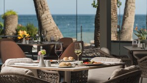 A dining area with tables set for two, overlooking the sea. - Plus Fariones Suite Hotel (Tías)