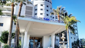 A hotel with a modern facade, palm trees, and a fountain in front. - Hotel TRH Paraiso (Estepona)