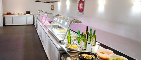 Un buffet proposant une variété de plats et de boissons en bouteille.
