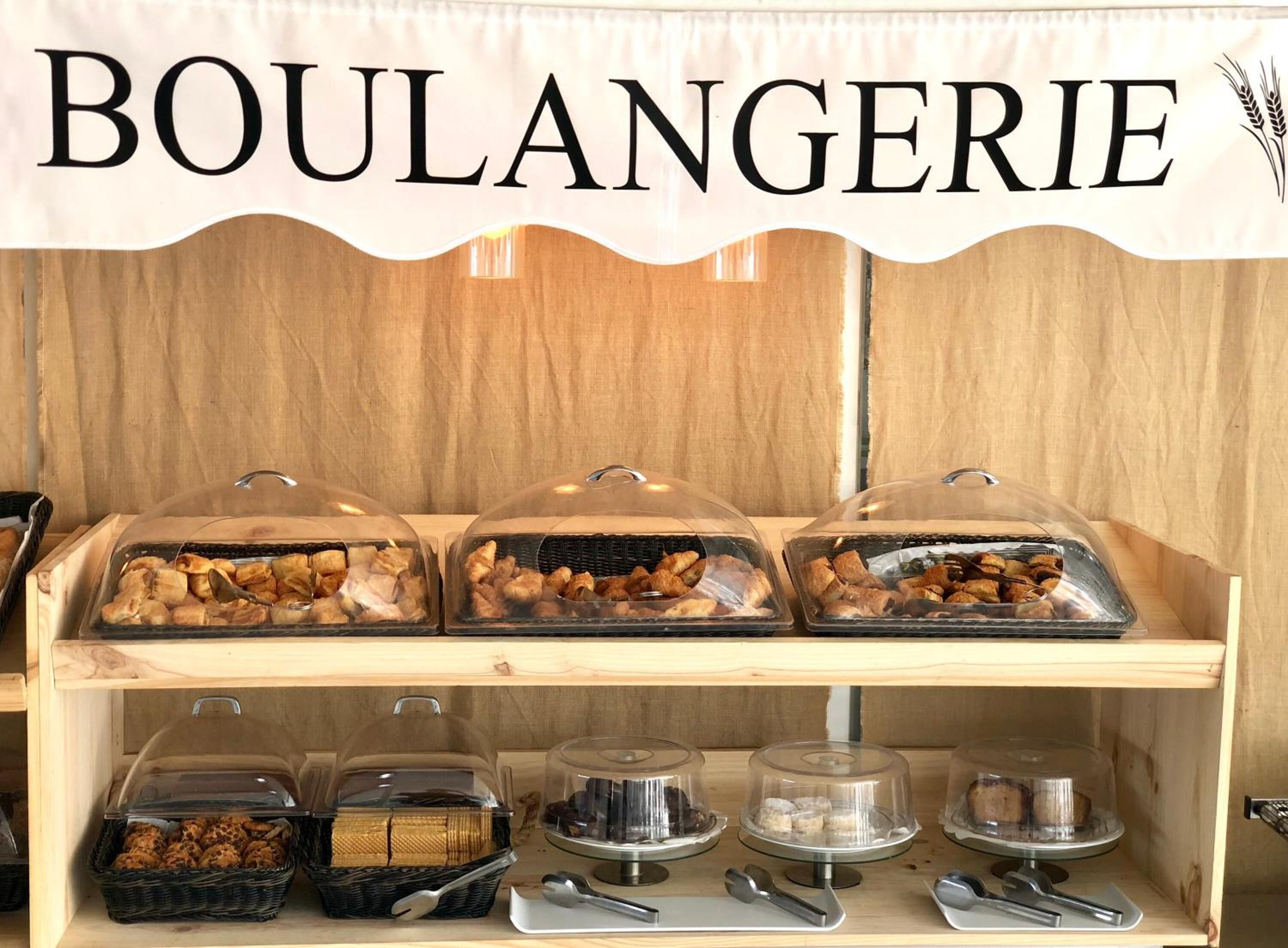 A bakery display with the sign 'BOULANGERIE' above, featuring various baked goods in clear containers.