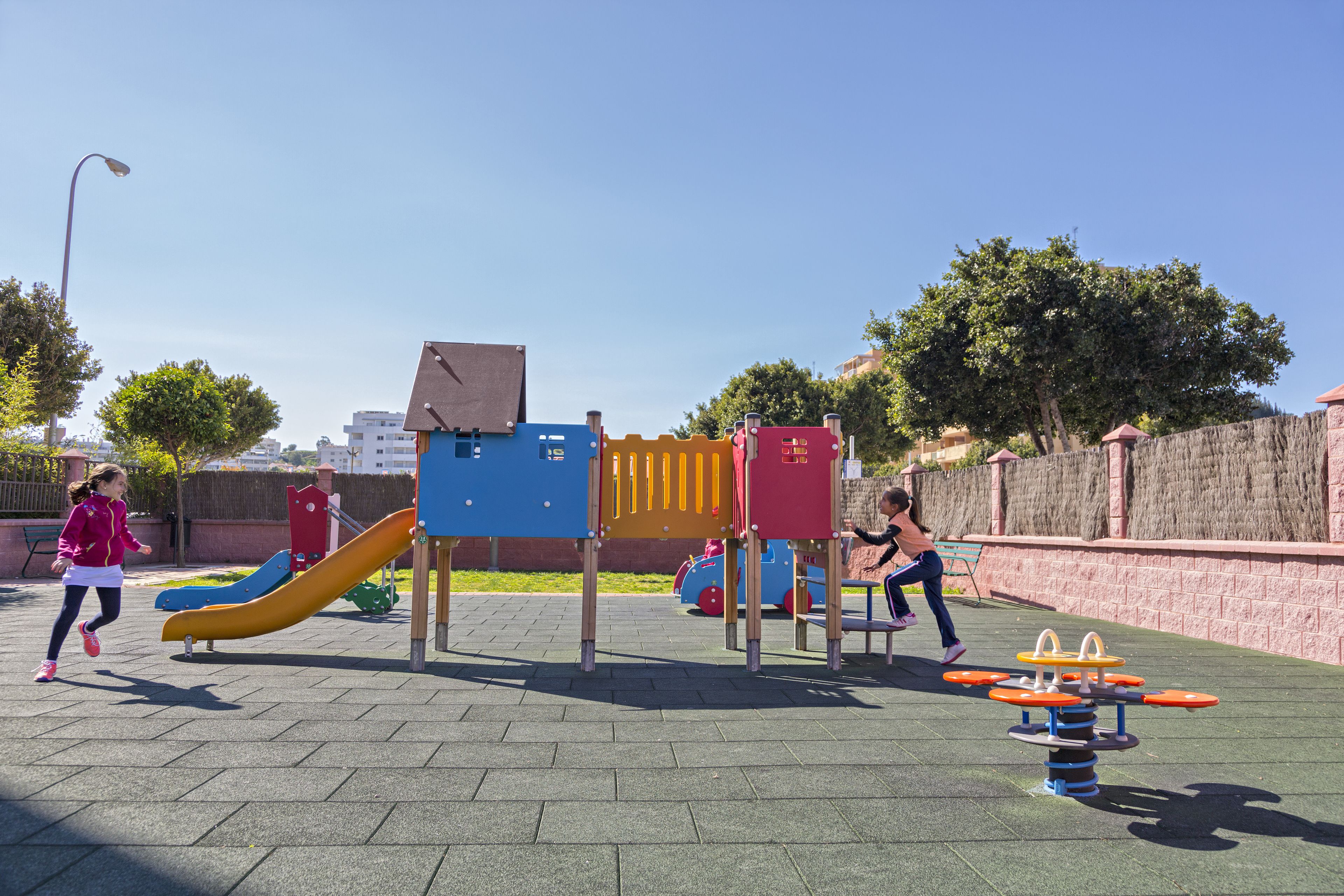 A playground with a slide, climbing structures, and exercise equipment.