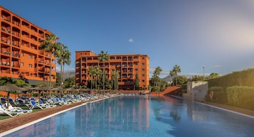 Una piscina cubierta, una piscina al aire libre de temporada, sombrillas