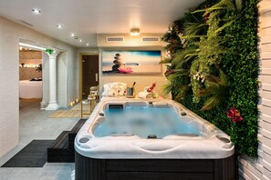 A spa area with a hot tub, a wall-mounted plant wall, and a serene painting. - Bluesea Alboran (Torremolinos)