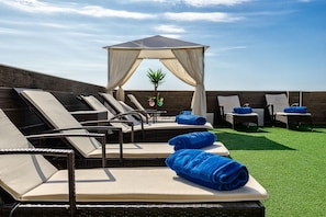 A rooftop lounge area with sun loungers, a canopy, and a small pool. - Bluesea Alboran (Torremolinos)