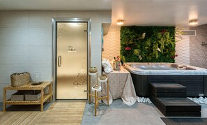 A modern bathroom with a glass door, a hot tub, a wall-mounted air conditioner, and a decorative plant wall. - Bluesea Alboran (Torremolinos)