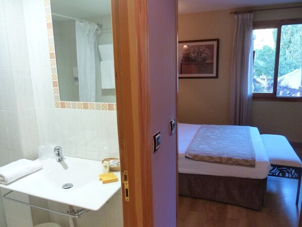 A bathroom with a sink, mirror, and shower. - Hotel Sabocos (Panticosa)